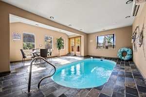 Enjoy a private, year-round heated indoor pool with 24/7 access! Perfect for families, couples, and groups, this space features a secure key door for child safety and scenic views. Relax in a climate-controlled oasis, ideal for any season.