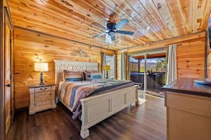 Unwind in this cozy king-size bedroom with a dresser, TV, closet, and private full bathroom. Step onto the balcony with seating to enjoy peaceful nature views. Designed for comfort and relaxation, this rustic retreat is perfect for a restful stay!
