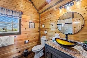 This full bathroom offers modern comfort with fresh towels, toilet paper, hand soap, body soap, and a hair dryer. Featuring a walk-in shower, granite vanity, and cozy cabin charm, it's stocked with essentials to ensure a refreshing & hassle-free stay