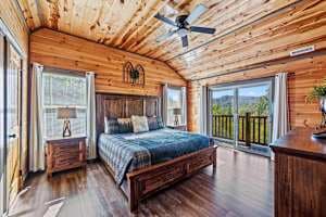 Unwind in this cozy king-size bedroom with a dresser, TV, closet, and private full bathroom. Step onto the balcony with seating to enjoy peaceful nature views. Designed for comfort and relaxation, this rustic retreat is perfect for a restful stay!
