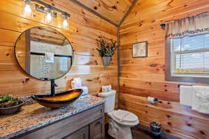 This full bathroom offers modern comfort with fresh towels, toilet paper, hand soap, body soap, and a hair dryer. Featuring a walk-in shower, granite vanity, and cozy cabin charm, it's stocked with essentials to ensure a refreshing & hassle-free stay