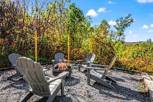 Cozy outdoor fire pit area with chairs, perfect for relaxing under the stars. Enjoy peaceful mountain views, crisp evening air, and unforgettable moments with family and friends in this serene Smoky Mountain retreat!